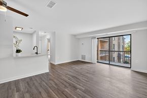 Washington apartment for rent - A spacious room with a ceiling fan and sliding glass doors.