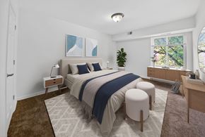 Washington apartment for rent - A bedroom with a large bed and a window overlooking trees.