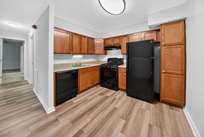Rockville apartment for rent - A kitchen with wooden cabinets and black appliances.