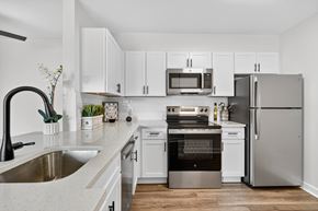 Washington apartment for rent - A modern kitchen with white cabinets and stainless steel appliances.