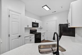 Spotsylvania apartment for rent - Renovated kitchen with white cabinets and black appliances