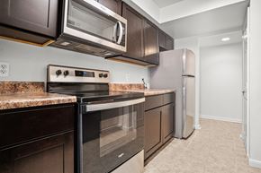 Washington apartment for rent - a kitchen with stainless steel appliances and dark wood cabinets