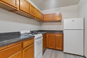 Washington apartment for rent - A kitchen with a white fridge, white stove and wooden cabinets.