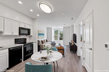 Fully equipped kitchen with modern white shaker cabinets, and black appliances