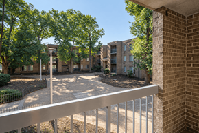 Washington apartment for rent - A view of a courtyard from a balcony with trees and buildings in the background.