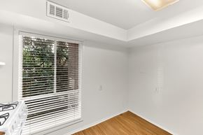 Washington apartment for rent - A room with a window covered by white blinds and a white gas stove.