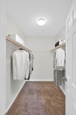 Washington apartment for rent - a walk in closet in a home with a carpeted floor and white clothes hanging