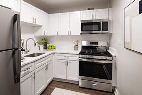 Hyattsville apartment for rent - A modern kitchen with white cabinets and stainless steel appliances.