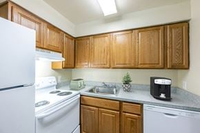 Washington apartment for rent - an empty kitchen with white appliances and wooden cabinets