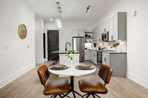 Nashville apartment for rent - A modern kitchen with a dining table set for two at Vintage Edge Nashville Apartments, Tennessee, 37211