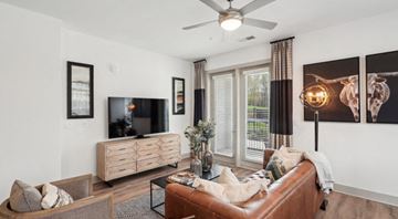 Raleigh apartment for rent - A living room with a brown leather couch and a flat screen TV.