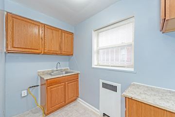 Washington apartment for rent - A kitchen with wooden cabinets and a white sink.