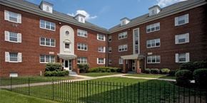 Silver Spring apartment for rent - A red brick building with a black fence at University Landing Apartments, Silver Spring