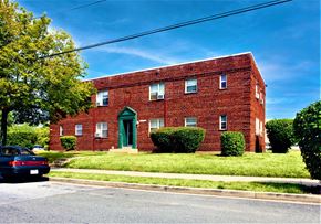 Washington apartment for rent - a red brick building with a green door and a blue sky in the background