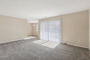 Towson apartment for rent - A spacious room with a carpeted floor and a sliding glass door.