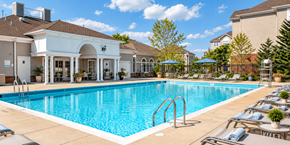 Suitland apartment for rent - A large swimming pool with a white building in the background.