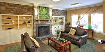 Glen Burnie apartment for rent - A living room with a fireplace and a painting on the wall.