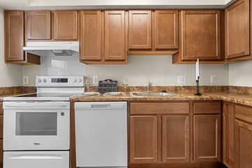 Silver Spring apartment for rent - A kitchen with brown cabinets and white appliances.