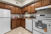 Silver Spring apartment for rent - A kitchen with white appliances and brown cabinets.