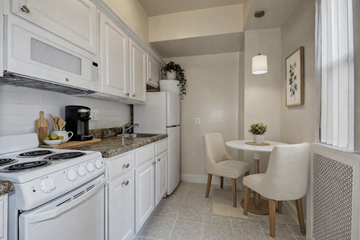 Washington apartment for rent - A kitchen with white appliances and a table with two chairs.