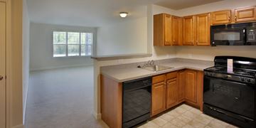 Aberdeen apartment for rent - A kitchen with black appliances and wooden cabinets.
