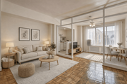 Washington apartment for rent - A living room with a white sofa, a coffee table, and a dining table.