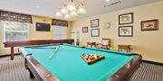 Mount Rainier apartment for rent - A pool table with a green cloth and a wooden cue stick. at Rainier Manor Apartments, Mount Rainier, MD, 20712