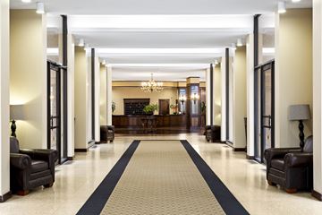 Silver Spring apartment for rent - A long hallway with a black and white carpet and black furniture on either side.
