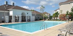 Suitland apartment for rent - A large swimming pool with a building in the background.