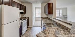 Suitland apartment for rent - a kitchen with white appliances and granite counter tops at Windsor Crossing, Maryland, 20746