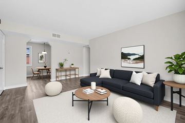 Capitol Heights apartment for rent - A living room with a black couch, a coffee table, and a large painting on the wall.
