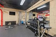 Washington apartment for rent - A gym with a variety of equipment including a bench press, a squat rack, and a rowing machine.