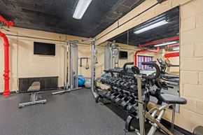 Washington apartment for rent - A gym with a variety of equipment including a bench press, a squat rack, and a rowing machine.