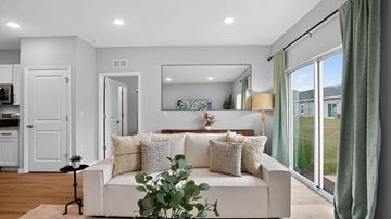 Ocala triplex for rent - A white couch with pillows and a plant on it in a living room.