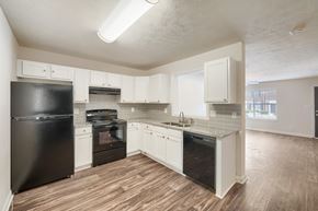 Commerce townhouse for rent - A kitchen with black appliances and white cabinets.