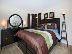 Greensboro apartment for rent - a bedroom with a bed and a dresser with a mirror