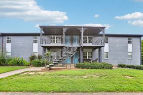 Doraville apartment for rent - A blue building with a balcony and stairs leading to the entrance.