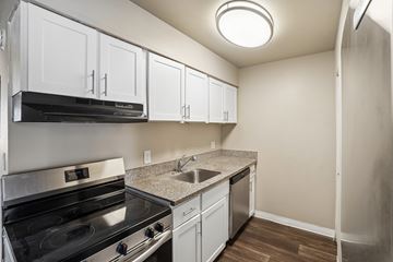 Thornton apartment for rent - A kitchen with white cabinets and a black stove top oven.