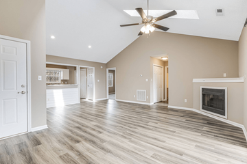 Asheville apartment for rent - A spacious living room with a fireplace and a ceiling fan.