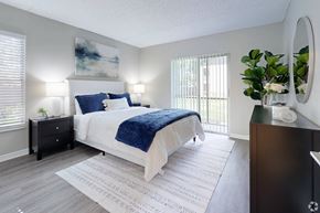 Largo apartment for rent - A bedroom with a large bed and a painting on the wall.