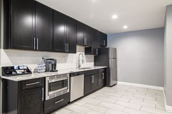 A kitchen with black cabinets and stainless steel appliances