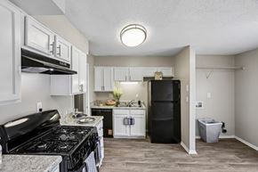 Doraville apartment for rent - A kitchen with black stove top and white cabinets.