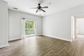 Goose Creek apartment for rent - A room with a ceiling fan and sliding glass doors leading to a balcony.