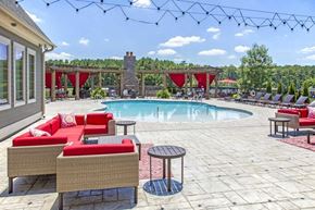 Birmingham apartment for rent - a swimming pool with red chairs and tables around it at Century Lakeshore Crossings, Birmingham, 35211
