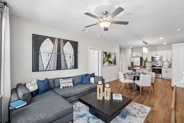 Knightdale apartment for rent - A modern living room with a grey sofa and a large abstract painting on the wall.