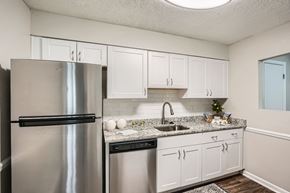 Marietta apartment for rent - A kitchen with a stainless steel refrigerator and white cabinets.