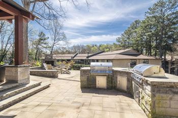 The backyard has an outdoor kitchen and a patio with a grill