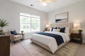Goose Creek apartment for rent - A bedroom with a large bed and a ceiling fan.