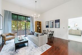 Atlanta apartment for rent - A living room with a grey couch, a coffee table, a chair, a bookshelf, and a dining table.