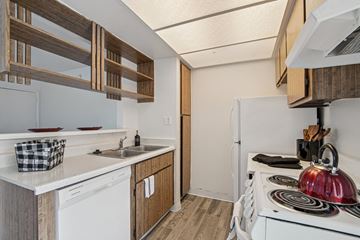 Phoenix apartment for rent - A small kitchen with a white stove top oven and a white dishwasher.